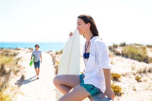 Teenager surfers walking to the beach in sunny summer day