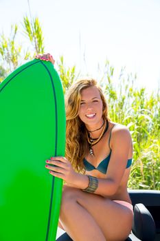 Blond teen surfer happy girl with green surfboard on California convertible car