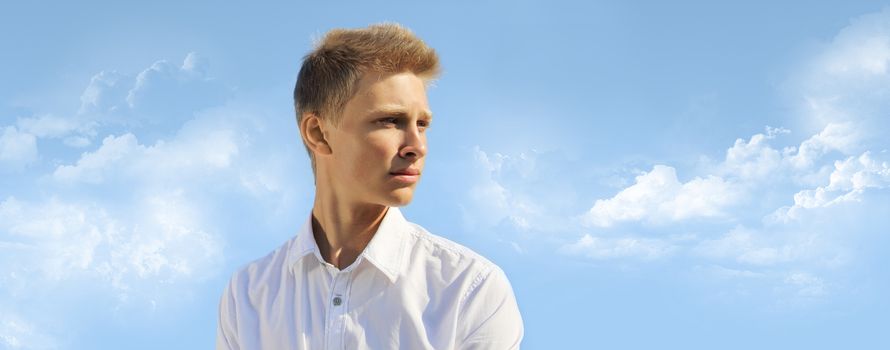 Handsome blond man on blue sky background at sunny day