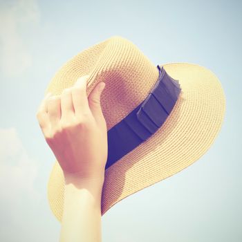 Woman hand holding panama hat with retro filter effect