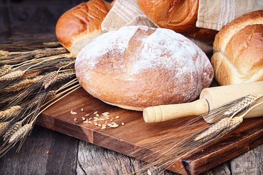 Variety of freshly baked breads and grain against a rustic background.