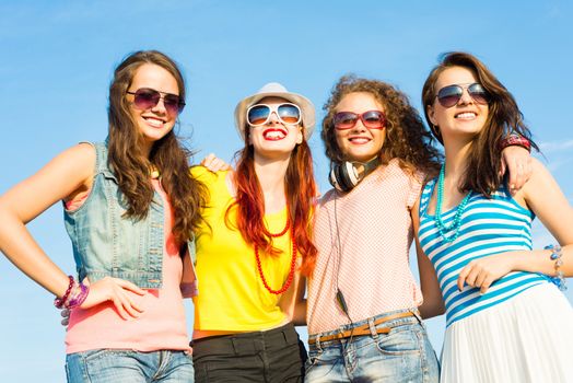 group of young people wearing sunglasses and hats hugging and standing in a row, spending time with friends