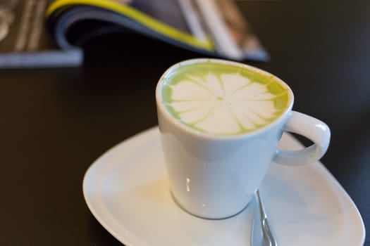 hot green tea in white cup on table