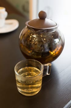 brown hot tea pot on table with tea cup