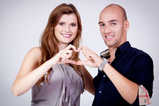 young attractive couple in love embracing portrait on grey backgound 