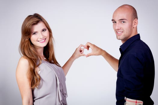 young attractive couple in love embracing portrait on grey backgound 