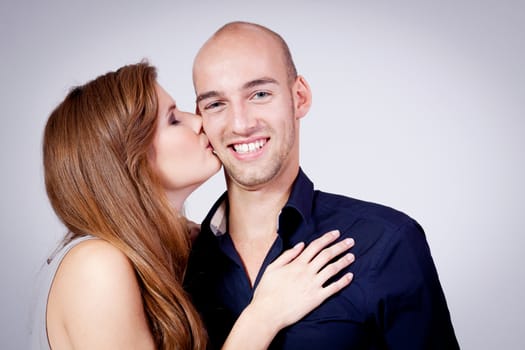 young attractive couple in love embracing portrait on grey backgound 