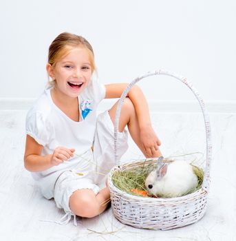 Cute smiling Little girl with a rabbit in basket