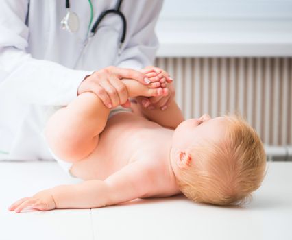 Masseuse massaging little baby girl