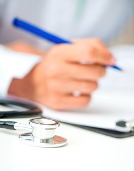 doctor's hands with a plane-table and pen on table