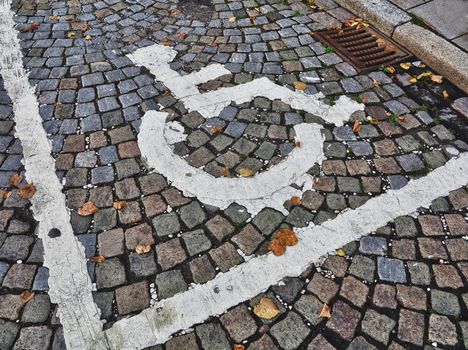 Grunge painted parking symbol for disabled in the old part of the city.