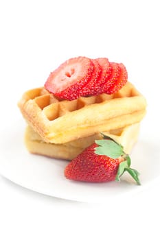 Belgian waffles and strawberry on a plate isolated on white