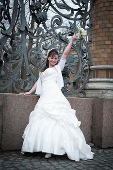 bride with bouquet in park fence