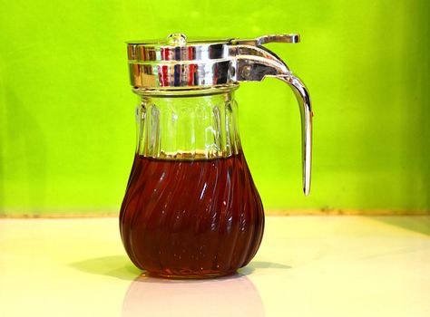 A bottle of maple syrup sits on a table