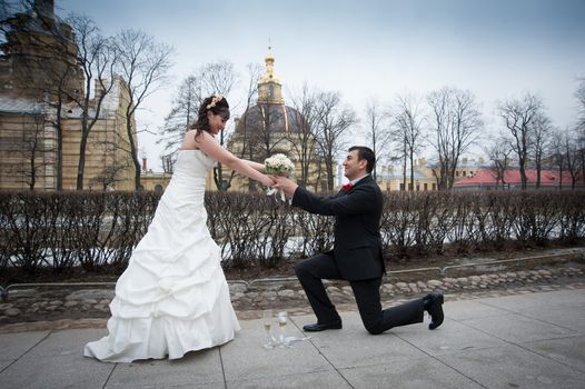 groom gives the bride a bouquet on her knees on the street