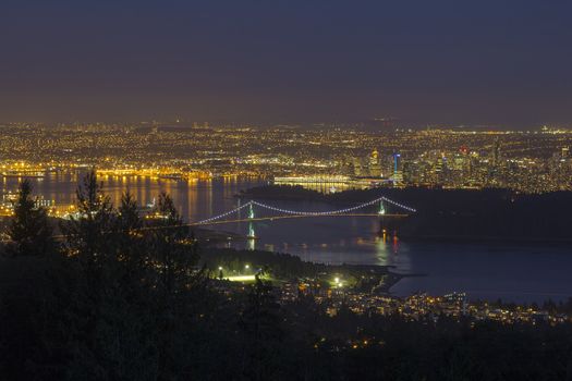 Vancouver BC Canada Cityscape with Stanley Park and Lions Gate Bridge Over Burrard Inlet at Evening Blue Hour