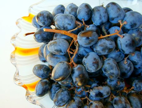 branch of green and black grapes on a plate