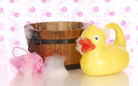 wooden wash tub and rubber duck with soap suds 