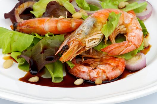 Delicious Salad with Fried Prawns, Mix Fresh Greens and Soy Sauce closeup on White plate