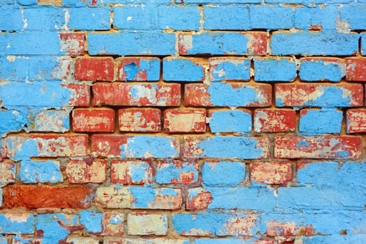 Fragment of old brick wall with shelled blue paint layers