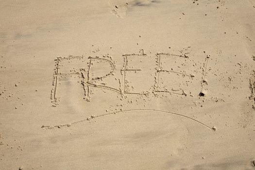 free word writing with small stones on sand beach ground