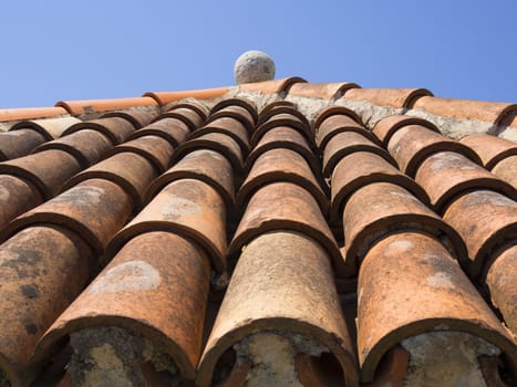 fragment of ancient tile roof with stone ball decoration on top