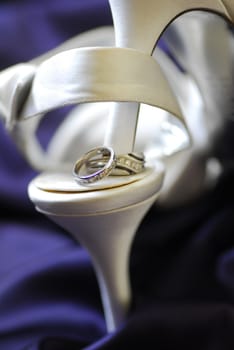 close up of wedding rings on white shoes