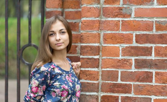 portrait of a beautiful young girl on a background of red bricks