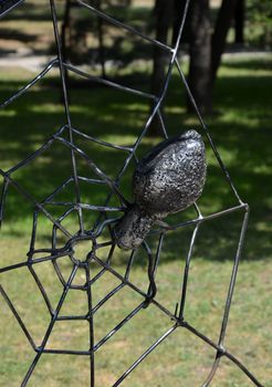 The forged metal spider on a web of wires