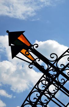 The fragment of decorative wrought bridge with lanterns against the sky and clouds