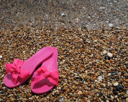 Pink slippers on the beach