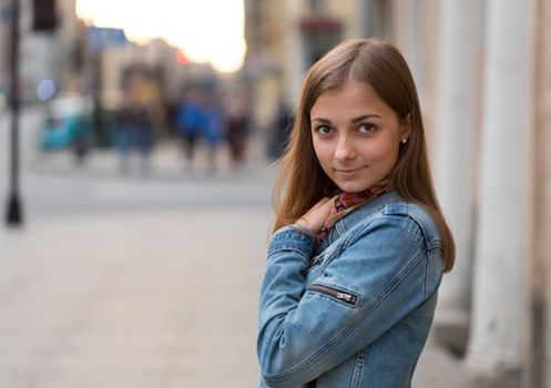 portrait of a beautiful girl in a jeans jacket on the street at night