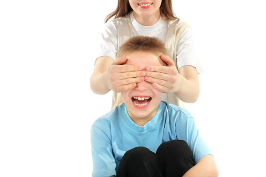 happy little boy and a girl behind him close his eyes