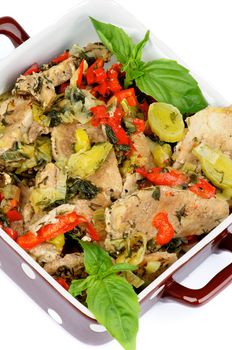 Slices of Delicious Stewed Pork with Leek, Red Bell Pepper and Greens in Brown Polka Dot Casserole Dish closeup on white background