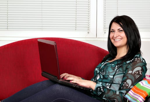 happy beautiful girl with laptop on bed