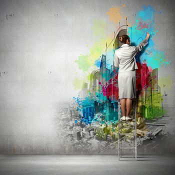 Back view of businesswoman drawing colorful business ideas on wall