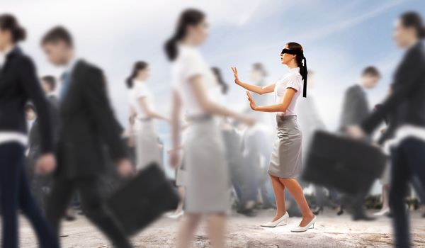 Image of businesswoman in blindfold walking among group of people