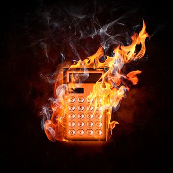 Image of calculator in fire flames against black background