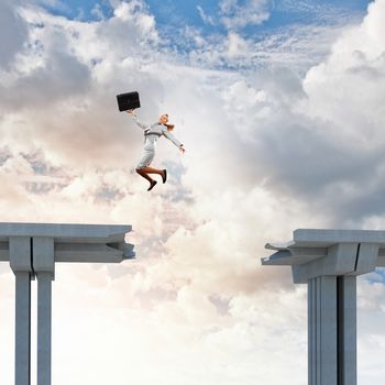 Young woman jumping over a gap in the bridge as a symbol of risk