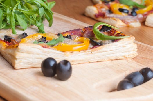 puff pastry cake with ruccola and olives