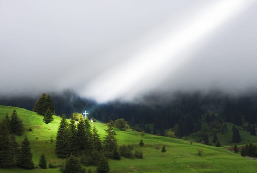 ray of light directly to the cross in a dense fog