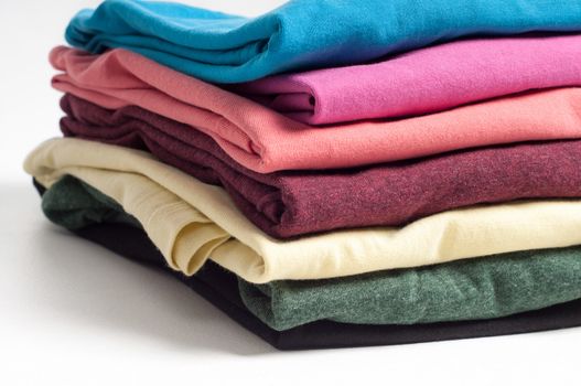 Stack of colored clothing on the light background