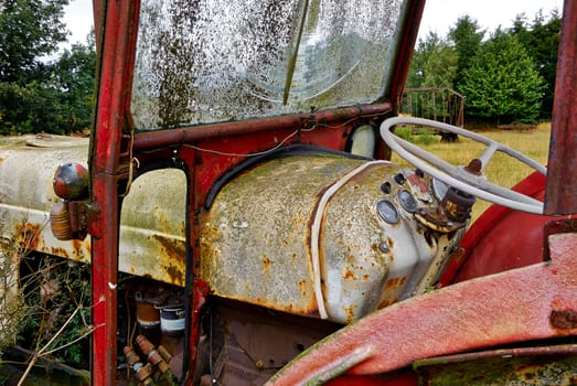 Close details of an old abandoned rusty tractor in a farm