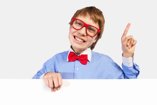 Image of young boy laughing holding white square. Place for advertisement