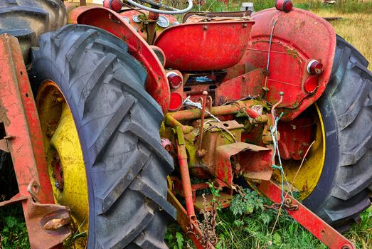 Close details of an old abandoned rusty tractor in a farm