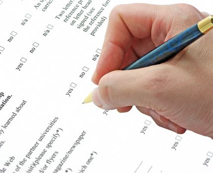Hand with pen completing a questionary