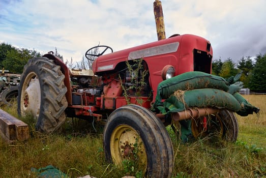 Close details of an old abandoned rusty tractor in a farm