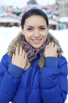 Caucasian young adult female smiling and walking down snow covered street