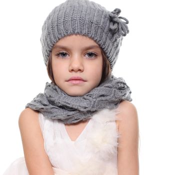 little girl in a knitted hat and gray scarf