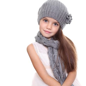 little girl in a knitted hat and gray scarf